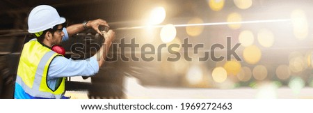 Mechanical engineer or professional maintenance technician wearing safety clothing is using a wrench to repair and inspect the undercarriage of the train, have double exposure images, and bokeh. Royalty-Free Stock Photo #1969272463