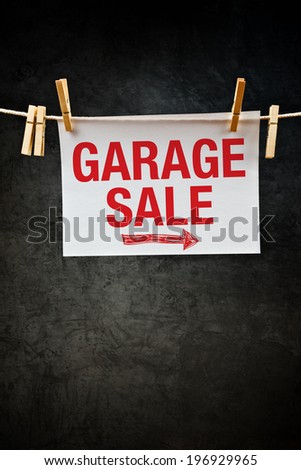 Garage Sale sign attached to rope with clothes pins.