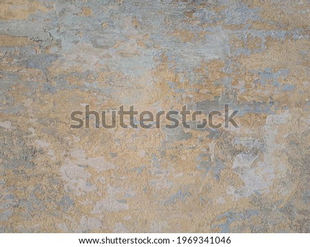 Peeling and cracked wall of an old house, light beige tone background
