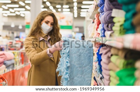 A young woman in a medical mask and gloves in a supermarket. Shopping during the Covid-19 coronavirus pandemic. Lockdown, restrictions. High quality photo