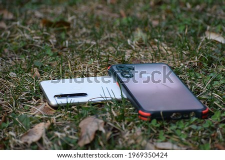 Beautiful picture of a mobile and mobile cover in green grass. Selective focus, Selective Focus On Subject, Background Blur