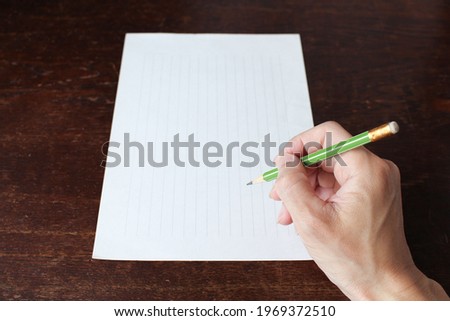 a notebook and a hand holding a pencil
