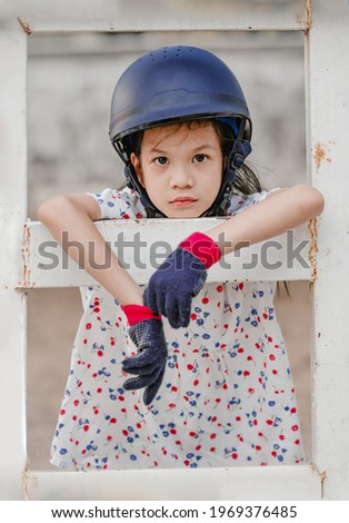 Asian school kid girl with horse, riding or practicing horse riding at the horse ranch.