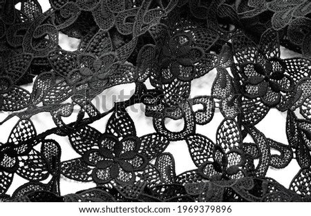 Lace fabric in black. Pure cotton lace with floral pattern embellished with embroidery. Light Transparency. Textured. Background. Pattern
