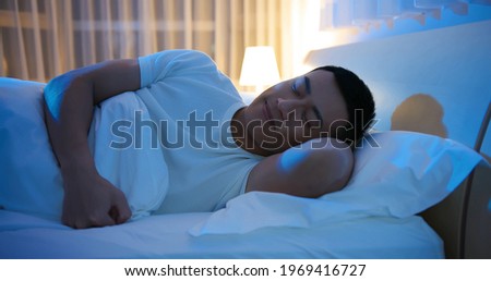 asian man sleep well with smile at night  Royalty-Free Stock Photo #1969416727
