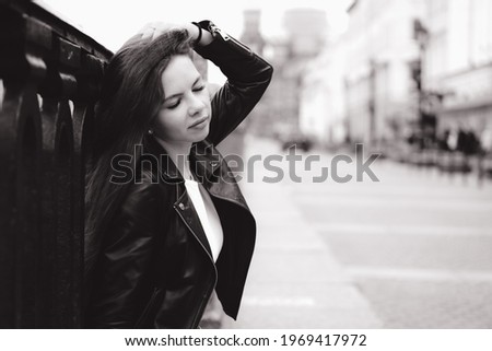 Young woman sitting at the street of a big city.