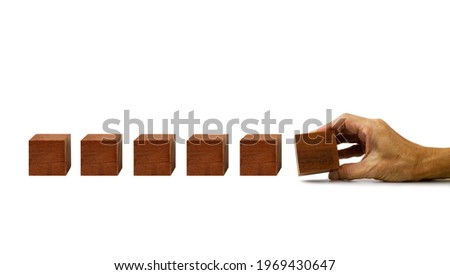 The hand establishes a blank (waiting for your text ) wooden cube in row on a white background  ,Cube block in hand