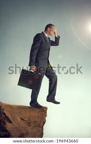 businessman with hands over eyes steps off a cliff Royalty-Free Stock Photo #196943660