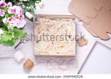 CBrown cardboard box with paper filler on wooden background 