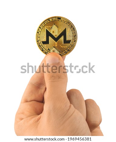 Monero cryptocurrency coin in hand isolated on white background photo