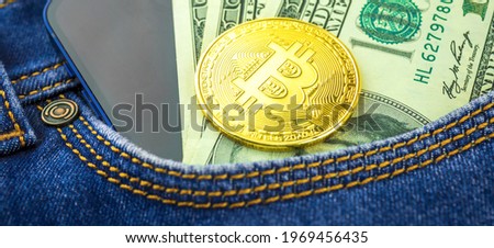Investment and trading banner background with golden bitcoin close-up, crypto currency in a pocket of blue jeans, US dollars photo