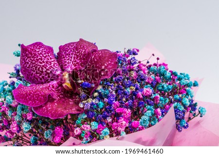 Beautiful bright bouquet with orchid on a light background.