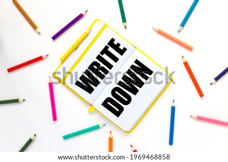 Write Down. bright open notebook on a white background and bright pencils