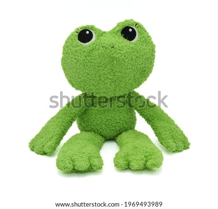 A green frog doll made with cloth  Sitting on a white background, isolated