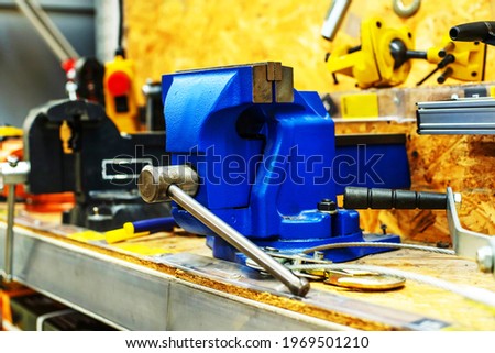 A blue metal vice on the counter of a building tools store. Close-up