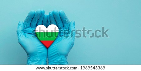 Doctors hands wearing surgical gloves holding Bulgaria flag heart