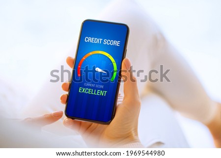 Woman looking at her credit score test on mobile phone showing excellent score Royalty-Free Stock Photo #1969544980