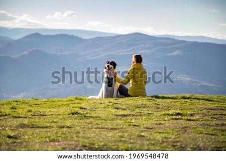 woman with dog relaxing in green spring landscape