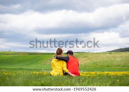 couple with dog relaxing in green spring landscape