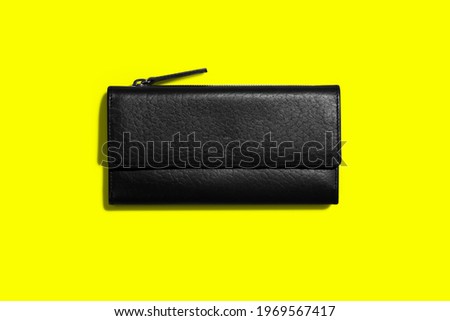 Fashionable leather women's wallet on a yellow background. added copy space for text.