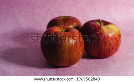 Close up of apple against pink background