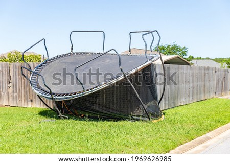 Trampoline damaged and flipped during severe storm Royalty-Free Stock Photo #1969626985