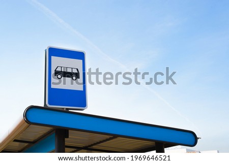 Public transport stop sign on light blue sky outside, copy space. Bus station on the route