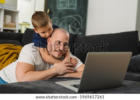 father and son using laptop computer at home