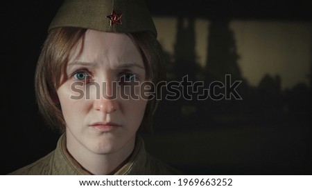 Photo of young woman in sorrow wearing red army uniform