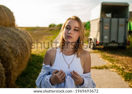 Young Beautiful Blonde Woman in a straw hat relaxing On Dry Hay In Summer