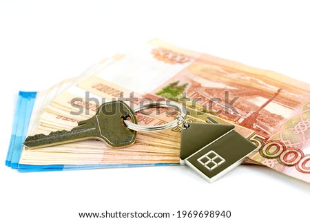 key to the apartment, money and a wooden house, the concept of buying a home