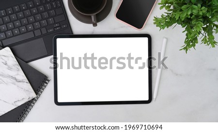Mock up digital tablet, mobile phone, notebook, coffee cup and houseplant on marble table. 