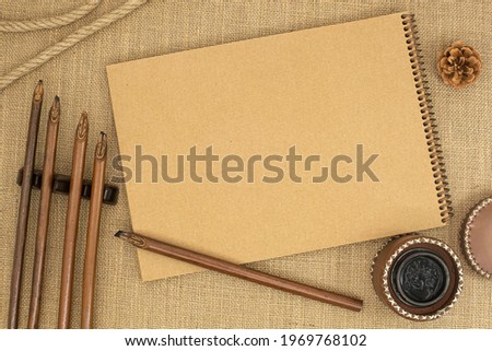 calligraphy workplace, mockup of calligraphy pens and inkwell, on notebook with space for Your own writing