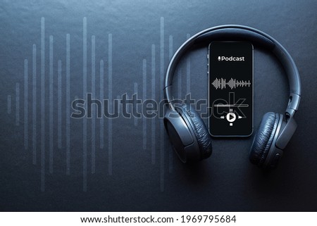 Podcast audio equipment. Audio microphone, sound headphones, podcast application on mobile smartphone screen. Recording sound voice on dark background. Live online radio player mockup banner Royalty-Free Stock Photo #1969795684