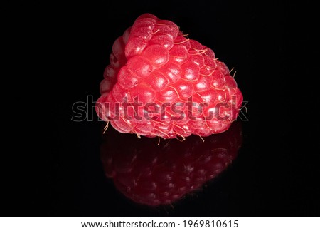 raspberry closeup on a reflecting black surface
