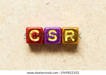 Metallic color alphabet letter block in word CSR (Abbreviation of corporate social responsibility) on wood background