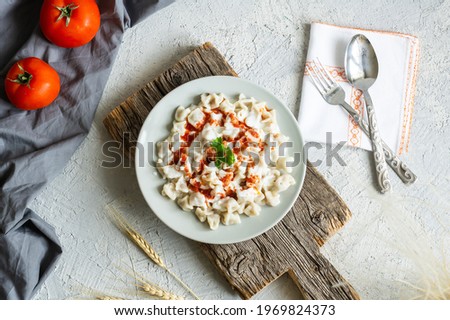 Turkish traditional food ravioli with yoghurt and tomato sauce in plate, manti Royalty-Free Stock Photo #1969824373