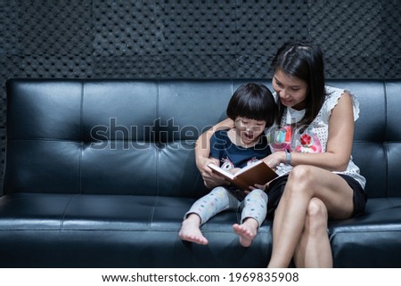 mother reading book for her child on bed, read cartoon book, Storytelling with children
