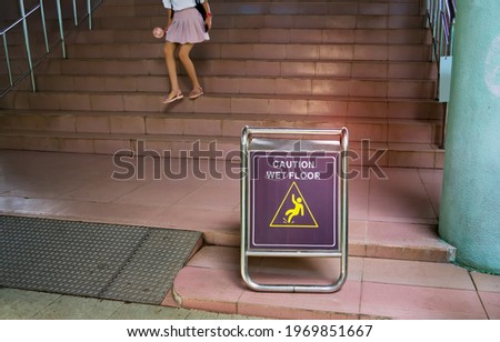 "Caution wet floor" sign with leg in on stairs steps