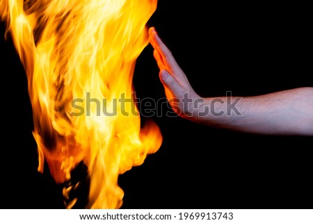 human hand and burning flame, use as a poster Royalty-Free Stock Photo #1969913743