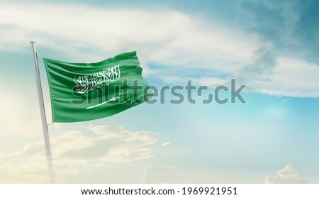 Saudi Arabia national flag waving in beautiful sky. Royalty-Free Stock Photo #1969921951