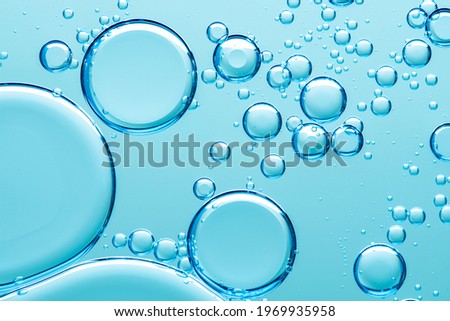 Beautiful and fantastic macro photo of water droplets in oil with a blue background. Abstract art 