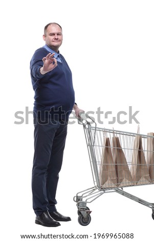 in full growth. casual mature man with shopping cart.