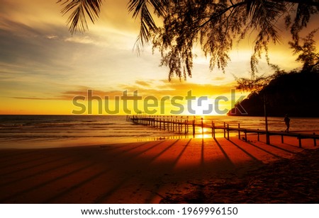 Wooden bridge, a pier on the beach And shadows at sunset, in the tropical sea of ​​Asia