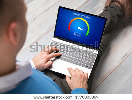 Man checking internet connection speed on laptop Royalty-Free Stock Photo #1970005069