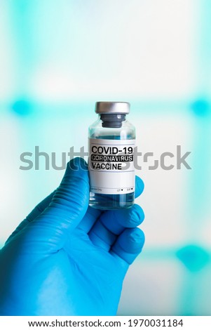 Hand with a bottle of vaccine for the vaccination program against covid-19 coronavirus. doctor holding a vial with doses of the covid-19 coronavirus vaccine
