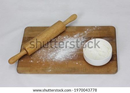 Women preparing rolling pin, Flour with wheat in the bowl. Splash flour on wooden cutting board over white table, baking background, top view, Copy space for text, menu, recipe. Banner Mock up recipe