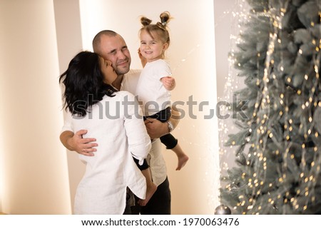 happy family in white shirts celebrate the new year. mom kisses dad
