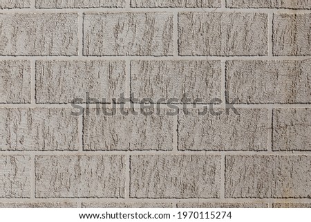 artificial brick-like pattern embossed in flat plaster surface