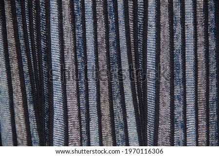 Striped gray-black-blue patterned fabric. Pleats on the fabric. Backgrounds